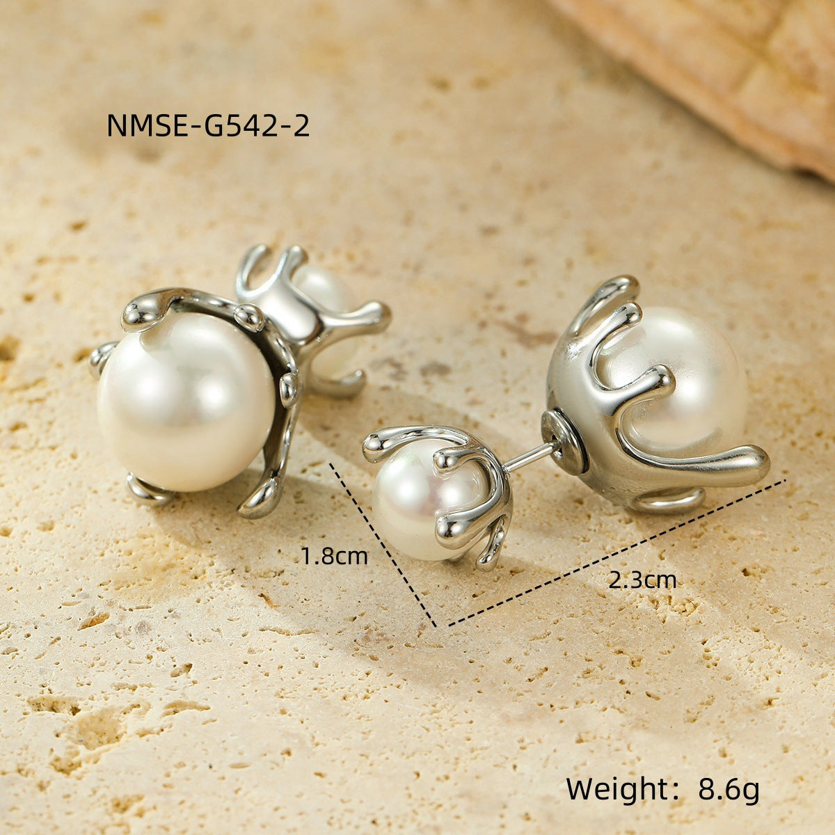 Pearl earrings with silver fixtures on a beige surface, showing measurements and weight.