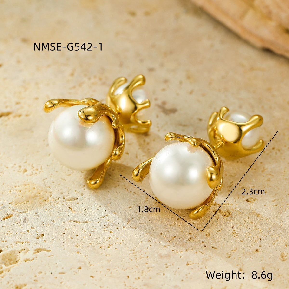 Gold earrings with pearls on a textured beige surface, showing measurements and weight.