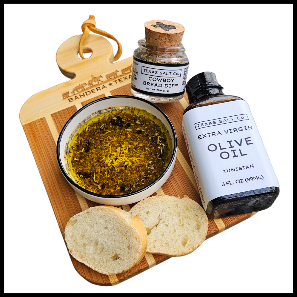 Bread, olive oil, and a jar of seasoning on a wooden board with 'Bandera Texas' branding.