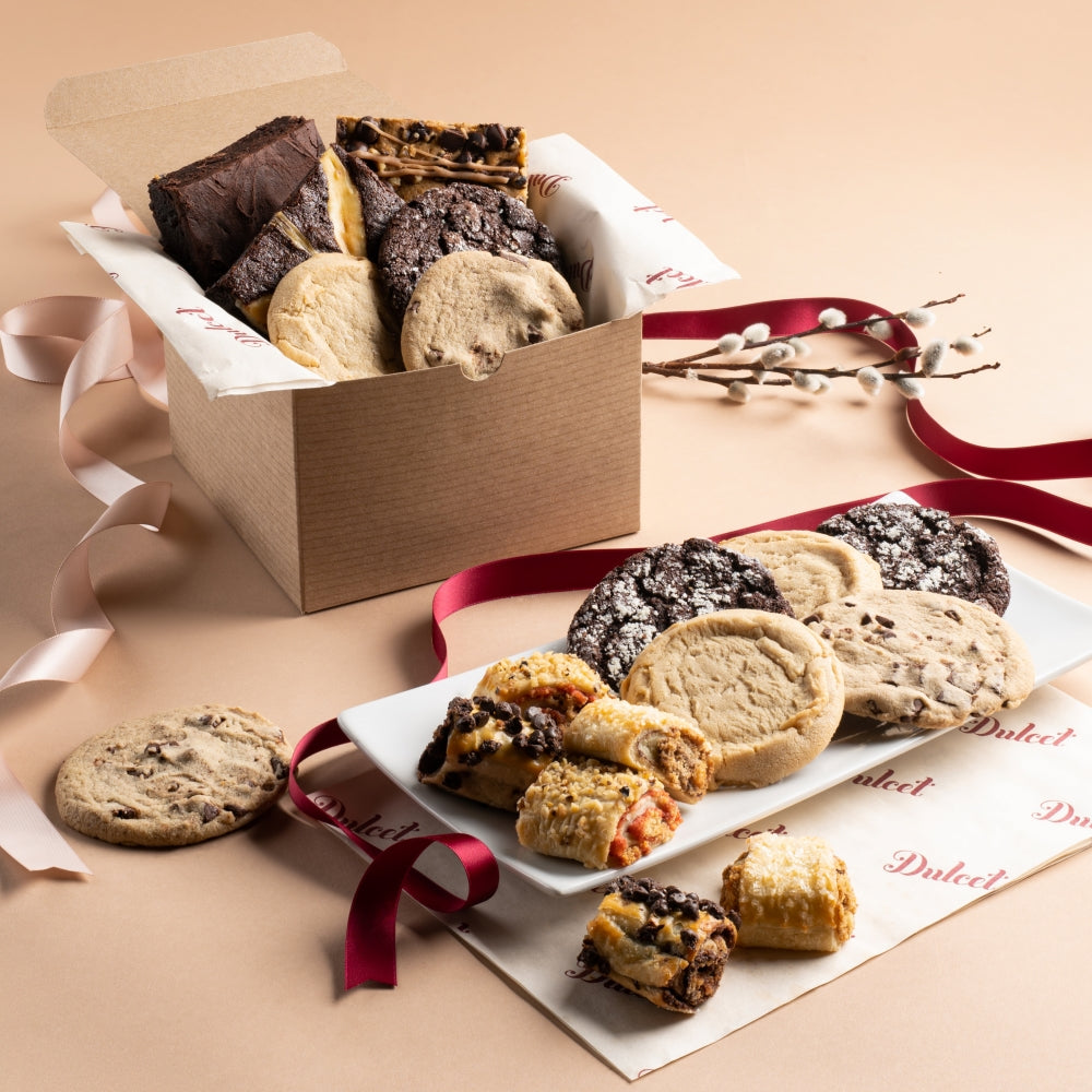 Assorted cookies in a box with a ribbon on a beige background