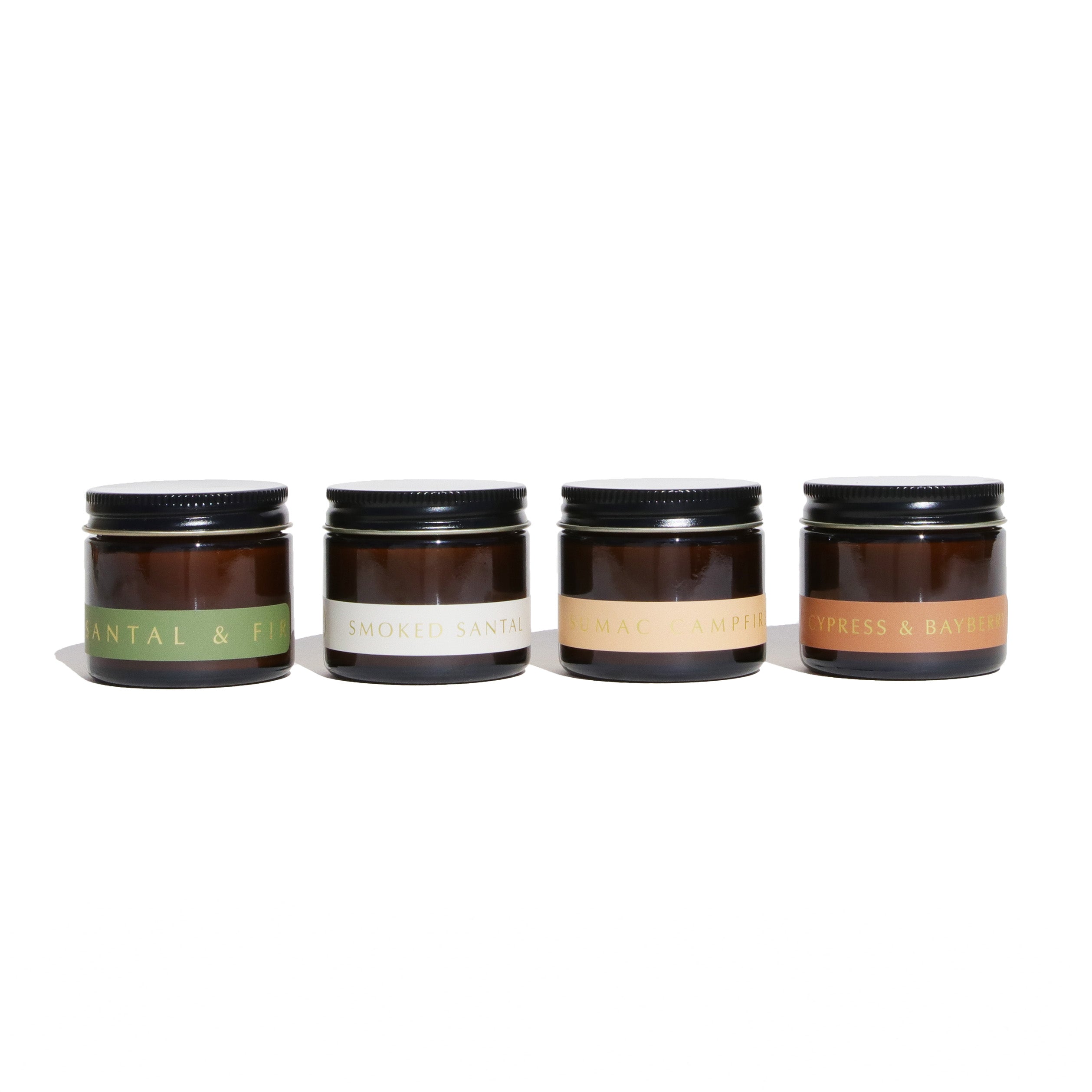 Four small jars with black lids on a white background