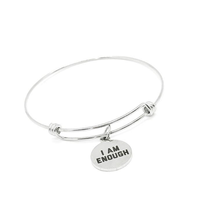 Silver bracelet with 'I AM ENOUGH' charm on a white background