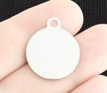 White circular pendant held in a hand against a black background